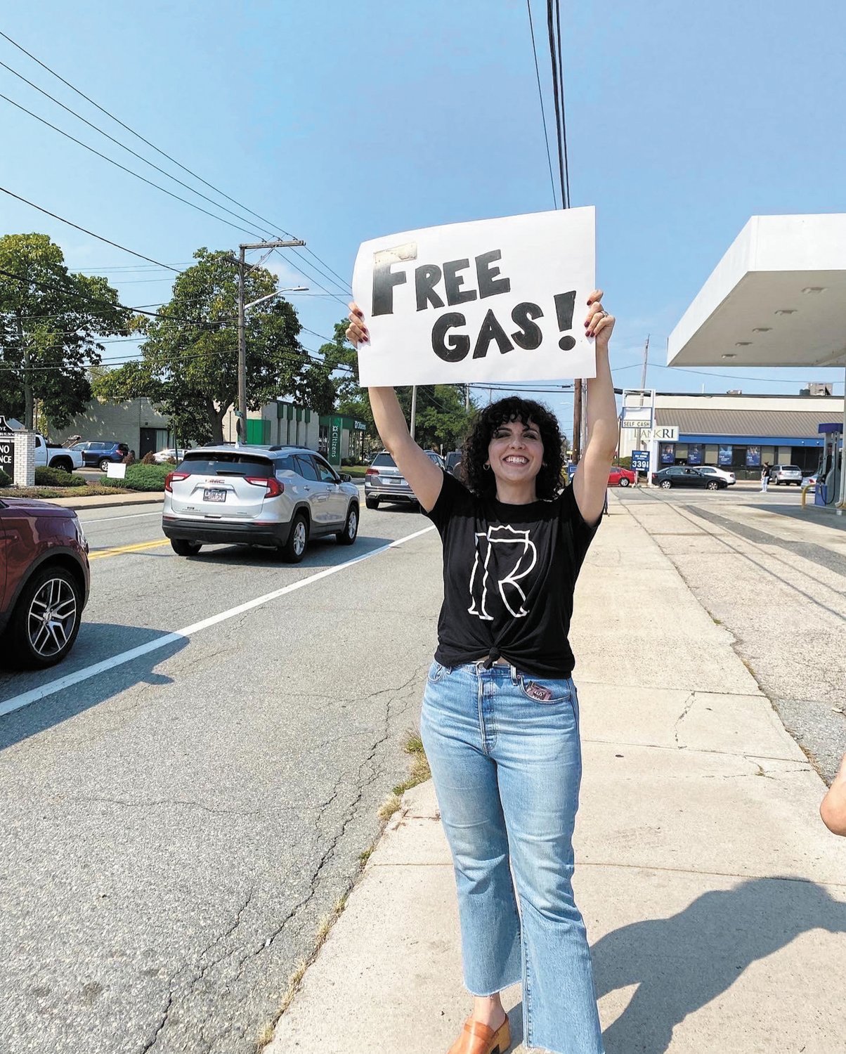 FREE GAS! STOP BY: Hannah McMillan held a sign outside Savers Mart on Park Avenue to let individuals know that Region Church was providing $20 worth of free gas for drivers.